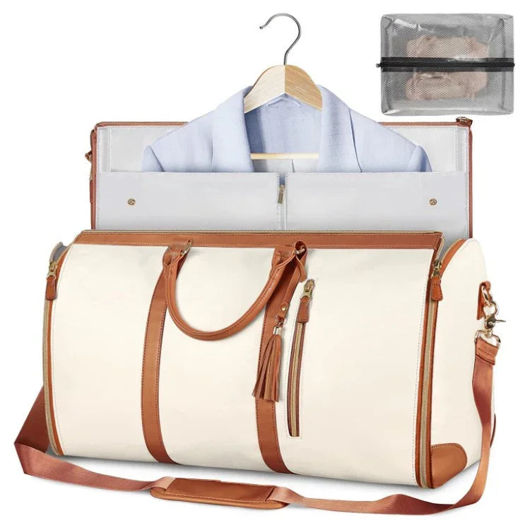 Cream duffel bag with brown straps, holding a suit on hanger, ideal for wrinkle-free travel