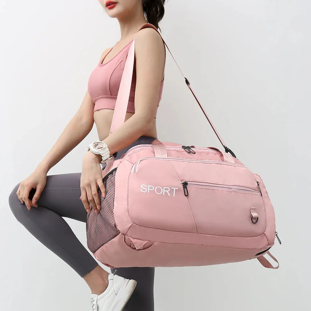 Pink sport duffel bag with mesh side pocket, worn by woman in athletic wear for gym or travel