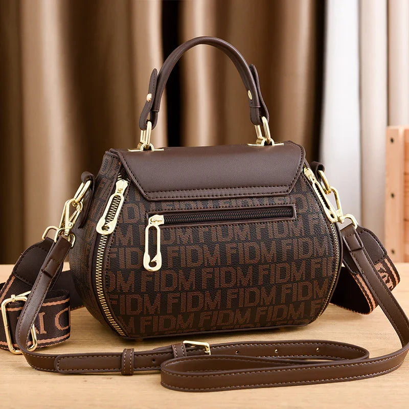 Brown monogram handbag with gold hardware, top handle, and detachable strap for stylish everyday carry.