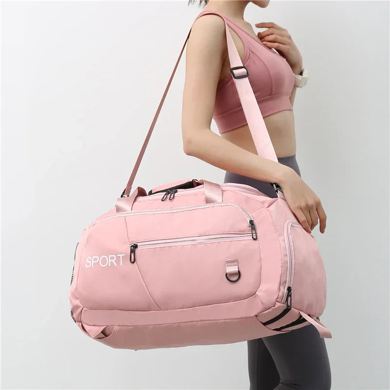 Pink sport duffel bag with multiple zippers, ideal for gym or travel, carried by woman in activewear